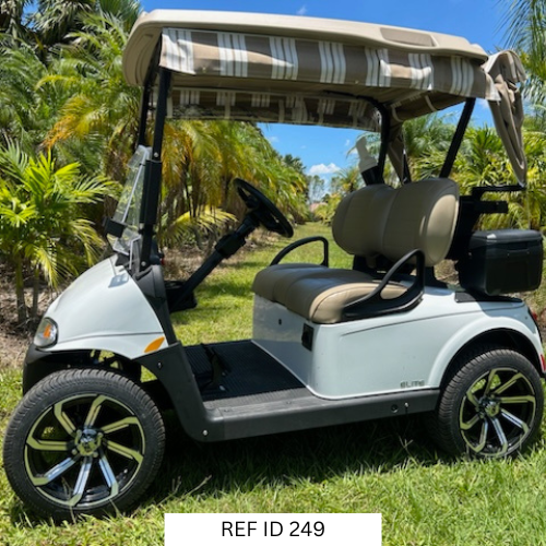 White E-Z-GO RXV Elite golf cart with 14-inch wheels, premium seats, and Sunbrella enclosure
